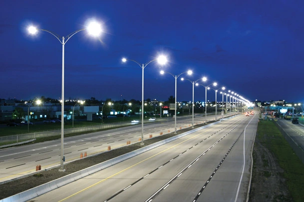 An empty highway at night with lit highway lighting all along the distance. 